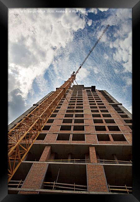 New house under construction with a tower crane against the blue sky and birds in the sky Framed Print by Sergii Petruk