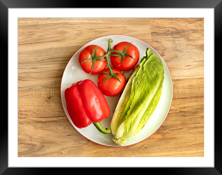Bulgarian pepper, tomato and romaine lettuce lie close-up on a white round porcelain plate against the background of a wooden table Framed Mounted Print by Sergii Petruk