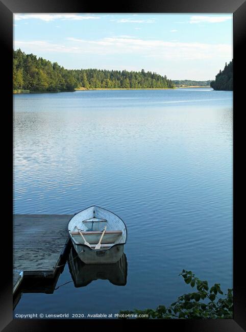 Calm lake with rowboat in Sweden Framed Print by Lensw0rld 