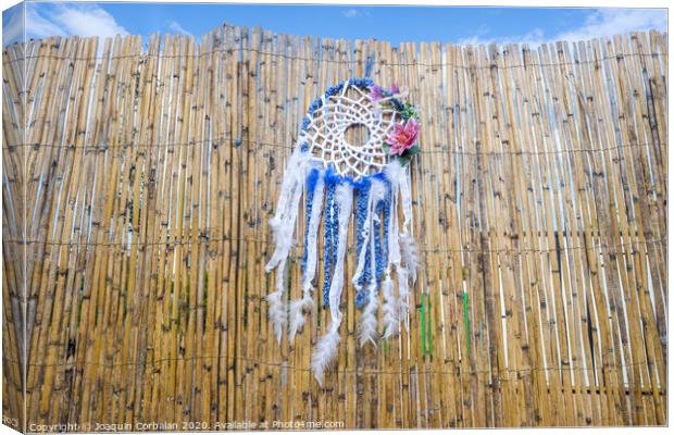 Vintage indigenous decoration hanging from a wall of old reeds, intense colors. Canvas Print by Joaquin Corbalan
