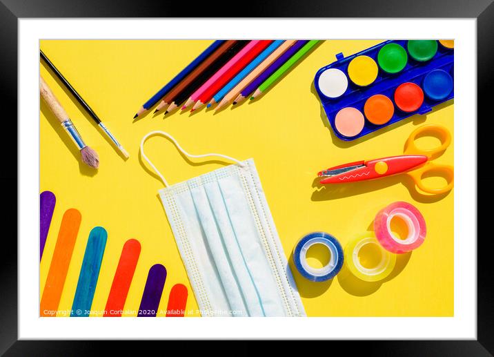 School supplies next to a face mask, flat lay background back to school. Framed Mounted Print by Joaquin Corbalan