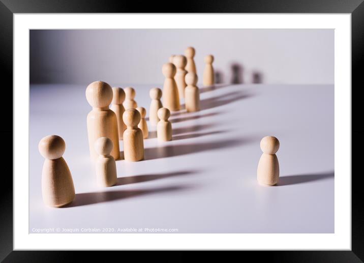 Social distance symbolized with wooden figures isolated from each other on white background. Framed Mounted Print by Joaquin Corbalan