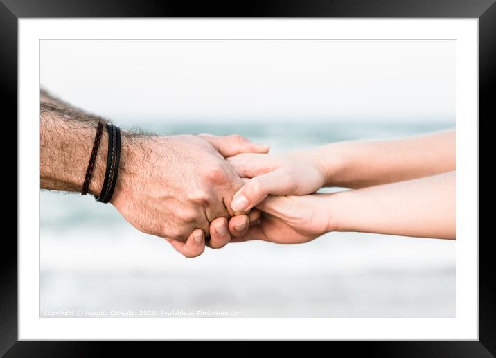 Two hands joined as a symbol of friendship with unfocused background. Framed Mounted Print by Joaquin Corbalan