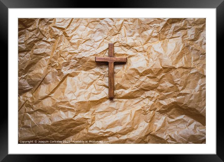Simple wooden religious cross on brown paper background. Framed Mounted Print by Joaquin Corbalan