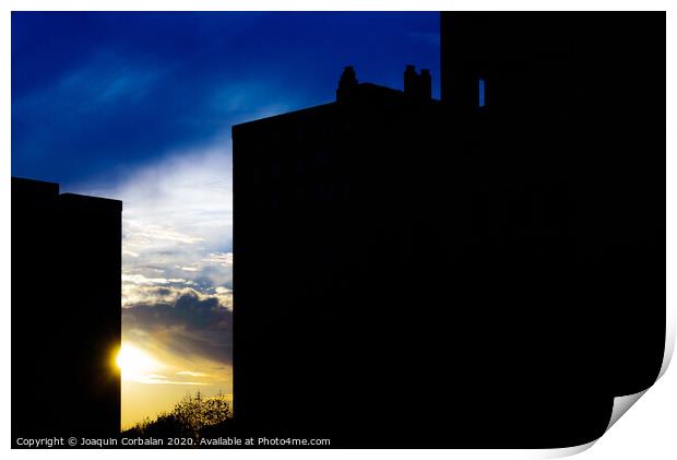 Sunset silhouette in a city with the warm sun behind buildings. Print by Joaquin Corbalan