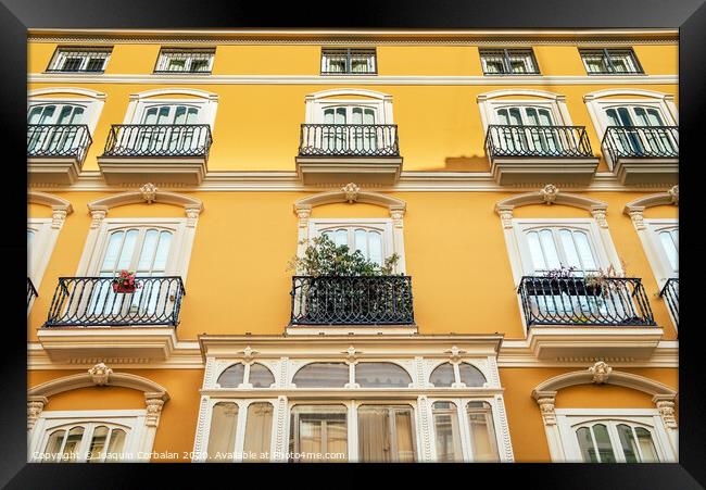 Bright facade of a typical old Mediterranean building painted in bright colors and warm tones. Framed Print by Joaquin Corbalan
