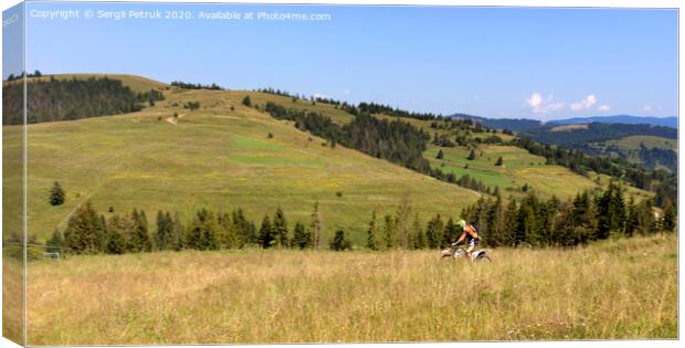Motorcyclist moves down the slope of the Carpathian Mountains Canvas Print by Sergii Petruk