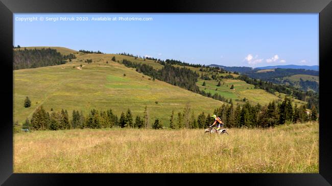 Motorcyclist moves down the slope of the Carpathian Mountains Framed Print by Sergii Petruk