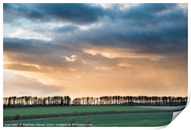 Beautiful stormy moody cloudy sky over English countryside landscape at dusk Print by Matthew Gibson