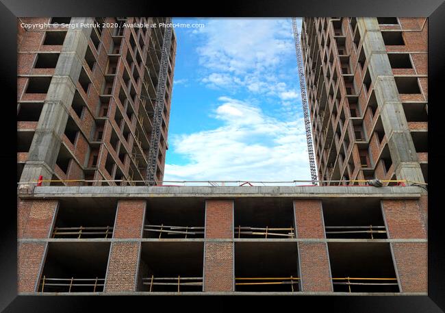 Two sections of a new house under construction against a blue sky with light white clouds Framed Print by Sergii Petruk