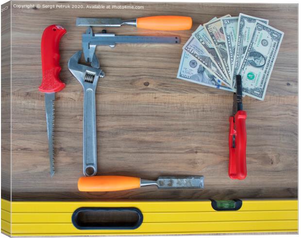 Old construction tools and a set of dollar bills on a wooden table close-up Canvas Print by Sergii Petruk