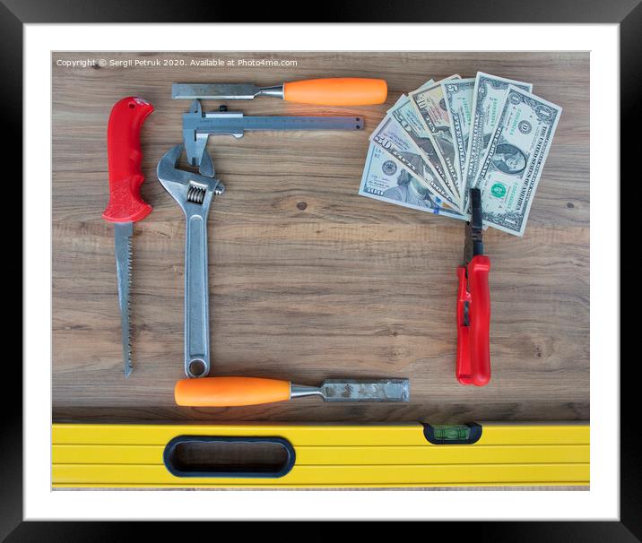 Old construction tools and a set of dollar bills on a wooden table close-up Framed Mounted Print by Sergii Petruk