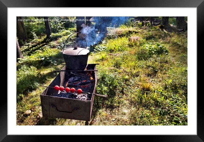 In the old cauldron on the barbecue cooking porridge against a forest clearing at noon Framed Mounted Print by Sergii Petruk