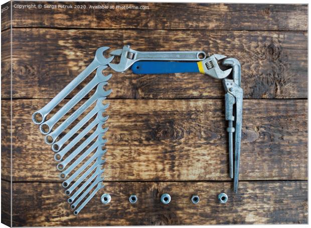 Set of combination wrenches and old adjustable wrenches on an old wooden background Canvas Print by Sergii Petruk