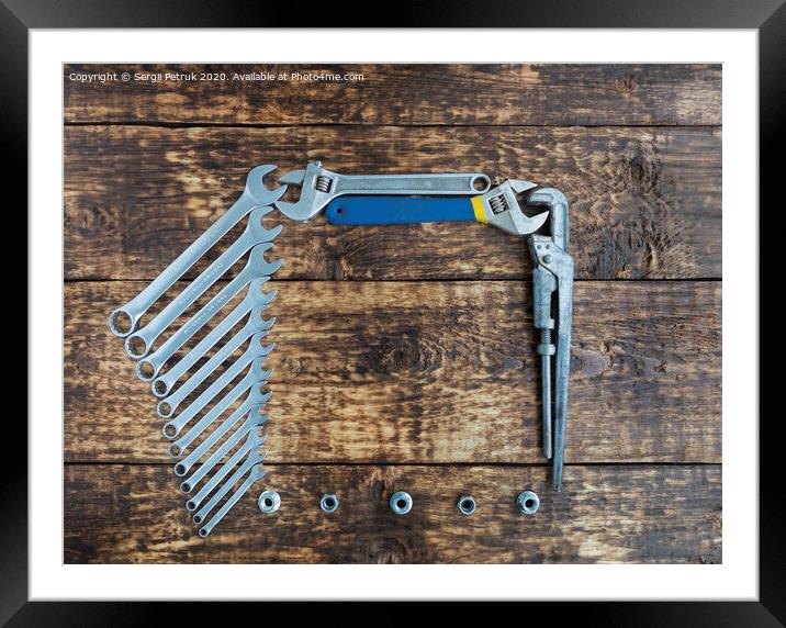 Set of combination wrenches and old adjustable wrenches on an old wooden background Framed Mounted Print by Sergii Petruk