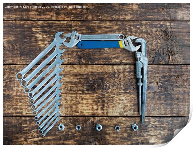 Set of combination wrenches and old adjustable wrenches on an old wooden background Print by Sergii Petruk
