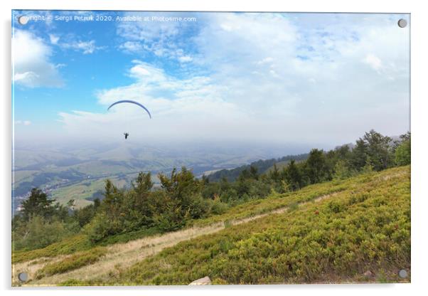 A flying paraglider against the blue sky, in the morning fog of the Carpathian Mountains Acrylic by Sergii Petruk