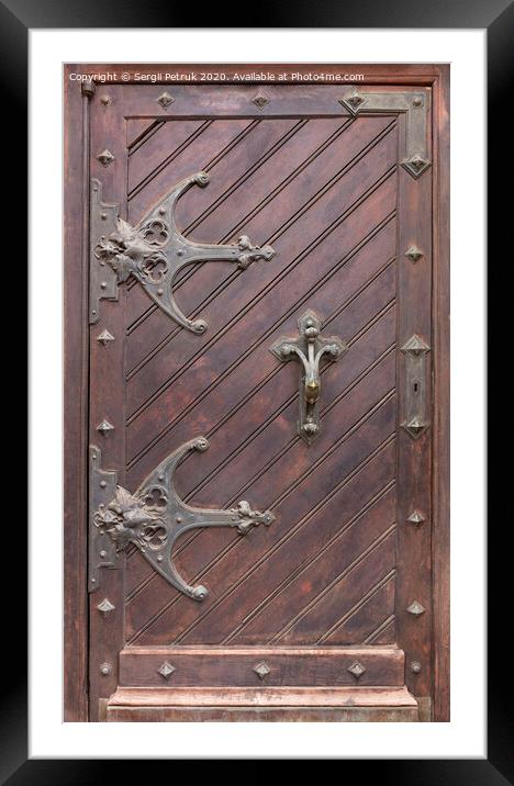 Ancient antique wooden doors with wrought iron loops and cross bars. Framed Mounted Print by Sergii Petruk