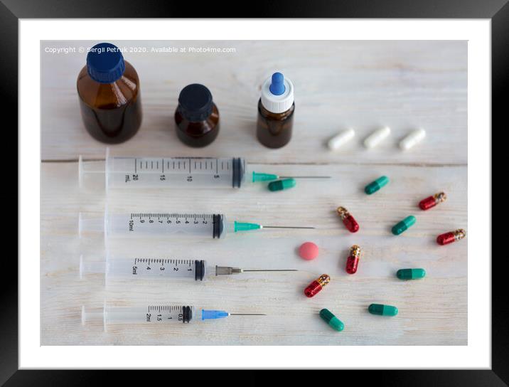 Syringes and capsules, medical ampoules and tablets on a white wooden table. Framed Mounted Print by Sergii Petruk