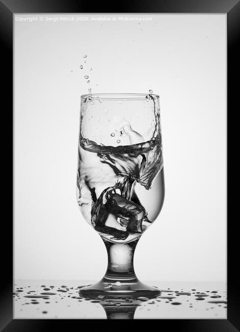 An ice cube falls into a glass glass with water Framed Print by Sergii Petruk