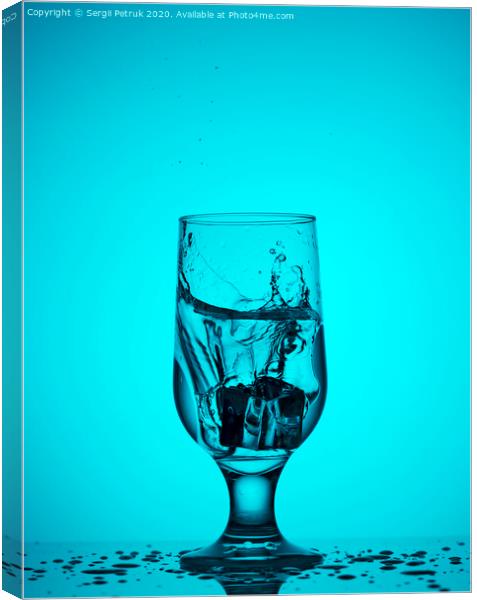 An ice cube falls into a glass glass with water Canvas Print by Sergii Petruk