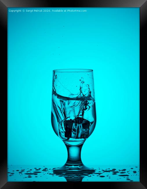 An ice cube falls into a glass glass with water Framed Print by Sergii Petruk