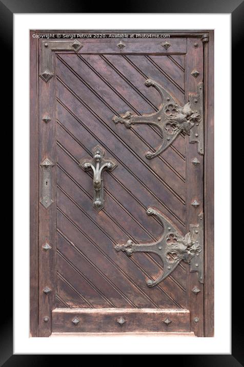 Ancient antique wooden doors with wrought iron loops and cross bars. Framed Mounted Print by Sergii Petruk