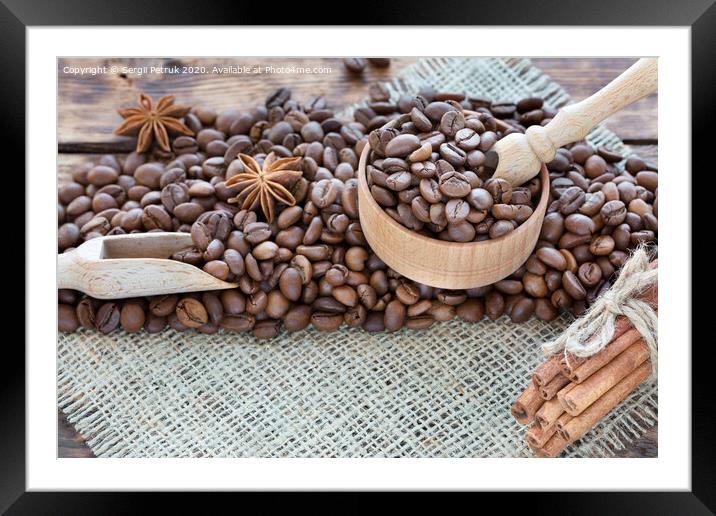 Grain coffee in a wooden cup and burlap. Cinnamon sticks are tied with string. Anise and dried slices of lemon on an old wooden board. Framed Mounted Print by Sergii Petruk