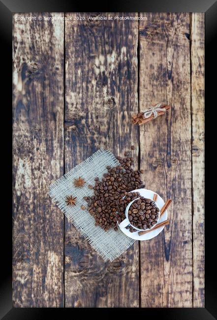Grain coffee in a cup, which stands on a sackcloth from burlap. Cinnamon on a platter and tied with a rope. Anise stars complement the aroma of coffee. View from above. Framed Print by Sergii Petruk