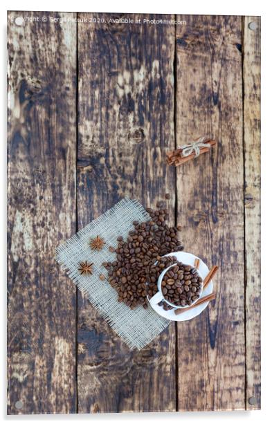Grain coffee in a cup, which stands on a sackcloth from burlap. Cinnamon on a platter and tied with a rope. Anise stars complement the aroma of coffee. View from above. Acrylic by Sergii Petruk