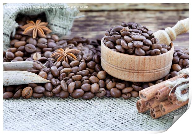 Grain coffee in a wooden cup and burlap. Cinnamon sticks are tied with string. Anise and dried slices of lemon on an old wooden board. Print by Sergii Petruk