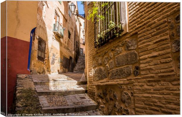 Medieval cobbled and stepped street in the city of Toledo. Spain Canvas Print by Mario Koufios