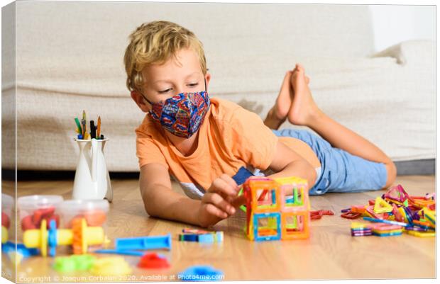 Young child plays at home with mask while recovering from covid infection. Canvas Print by Joaquin Corbalan