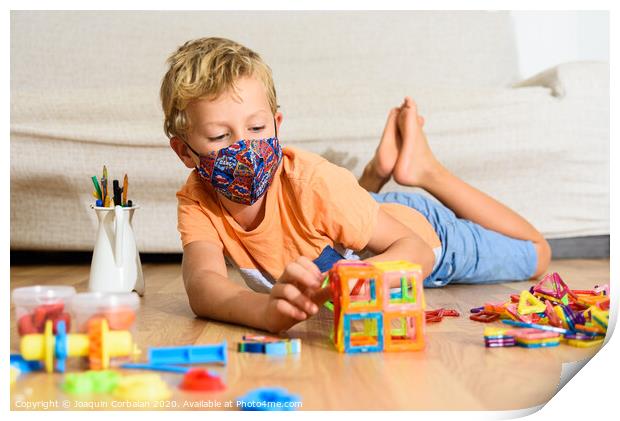 Young child plays at home with mask while recovering from covid infection. Print by Joaquin Corbalan