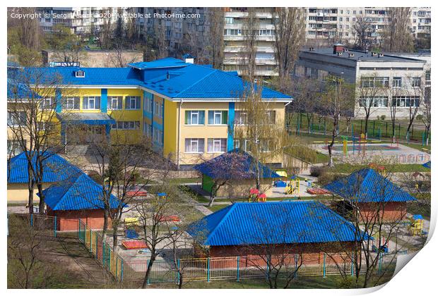 Bright blue roof of kindergarten against the background of gray urban high-rise buildings Print by Sergii Petruk
