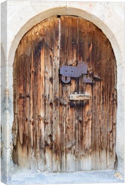 Ancient arched antique wooden doors with a metal lock in the middle Canvas Print by Sergii Petruk