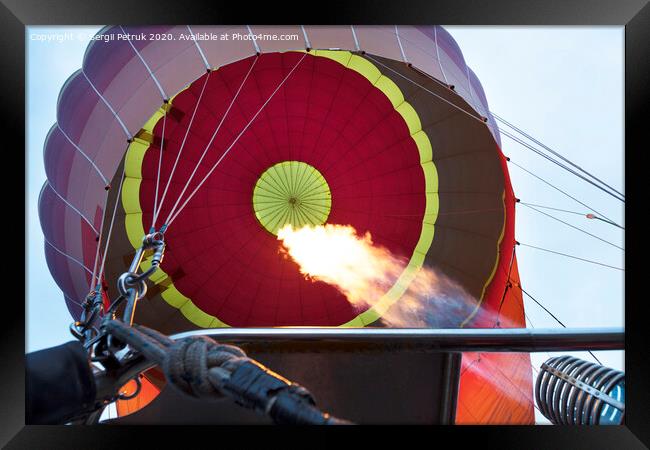 The flame of a gas burner inflates a balloon Framed Print by Sergii Petruk
