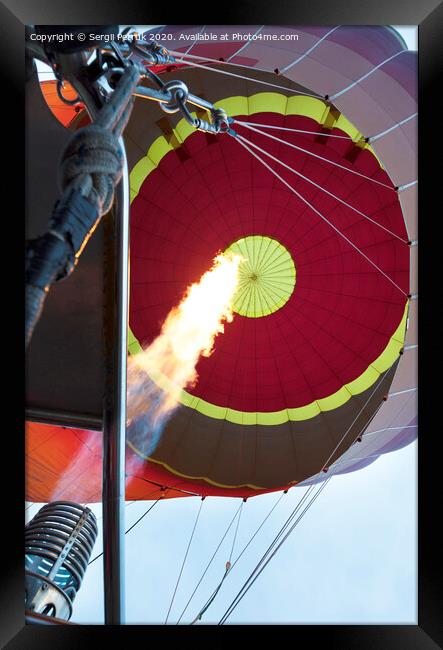 The flame of a gas burner inflates a balloon Framed Print by Sergii Petruk