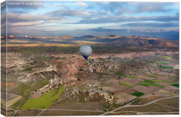 A balloons is flying over the valley in Cappadocia Canvas Print by Sergii Petruk