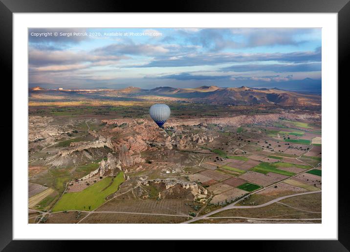 A balloons is flying over the valley in Cappadocia Framed Mounted Print by Sergii Petruk