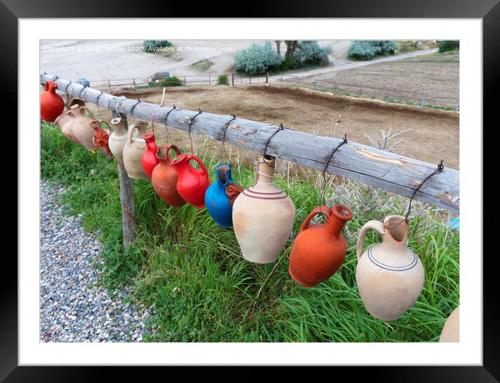 The multi-colored clay pots of desires hang tied on a wooden crossbar in Cappadocia. Framed Mounted Print by Sergii Petruk