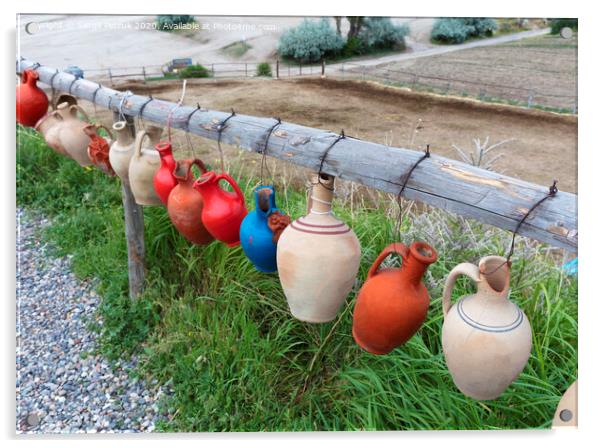 The multi-colored clay pots of desires hang tied on a wooden crossbar in Cappadocia. Acrylic by Sergii Petruk