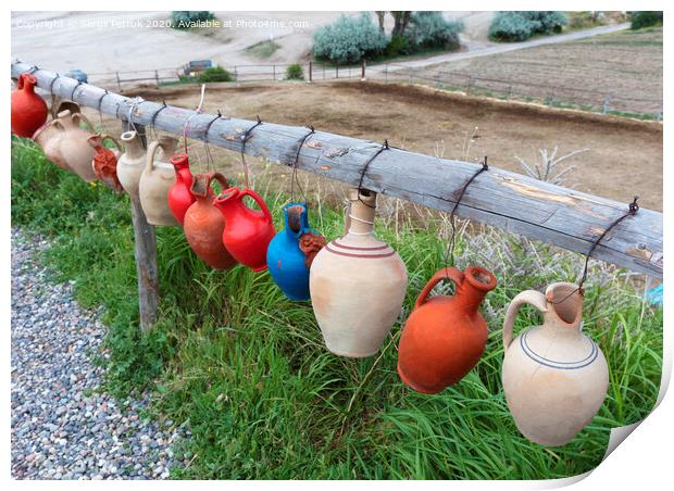 The multi-colored clay pots of desires hang tied on a wooden crossbar in Cappadocia. Print by Sergii Petruk