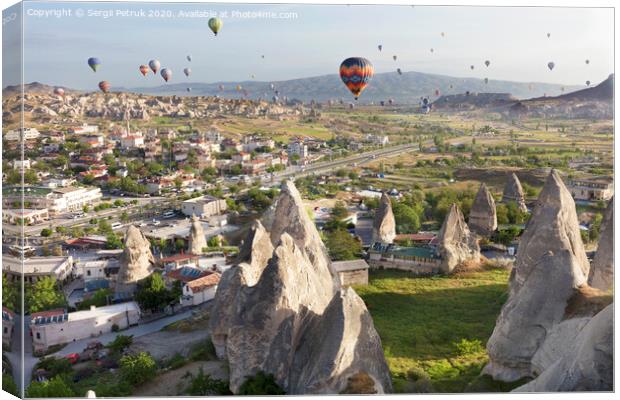 Dozens of balloons fly over the valleys in Cappadocia Canvas Print by Sergii Petruk