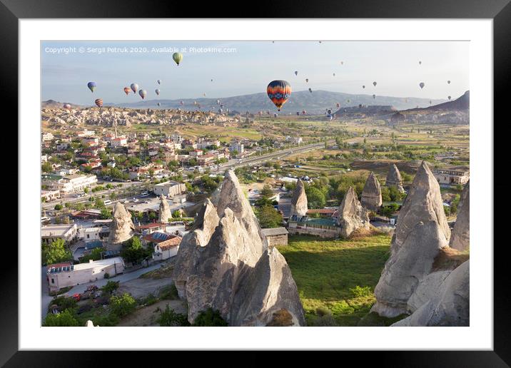 Dozens of balloons fly over the valleys in Cappadocia Framed Mounted Print by Sergii Petruk