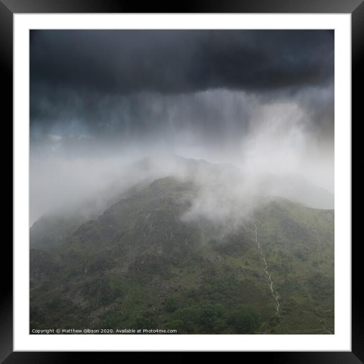 Dramatic landscape image of storm clouds hanging over Snowdonia mountain range with heavy rainfall in Autumn with misty weather Framed Mounted Print by Matthew Gibson