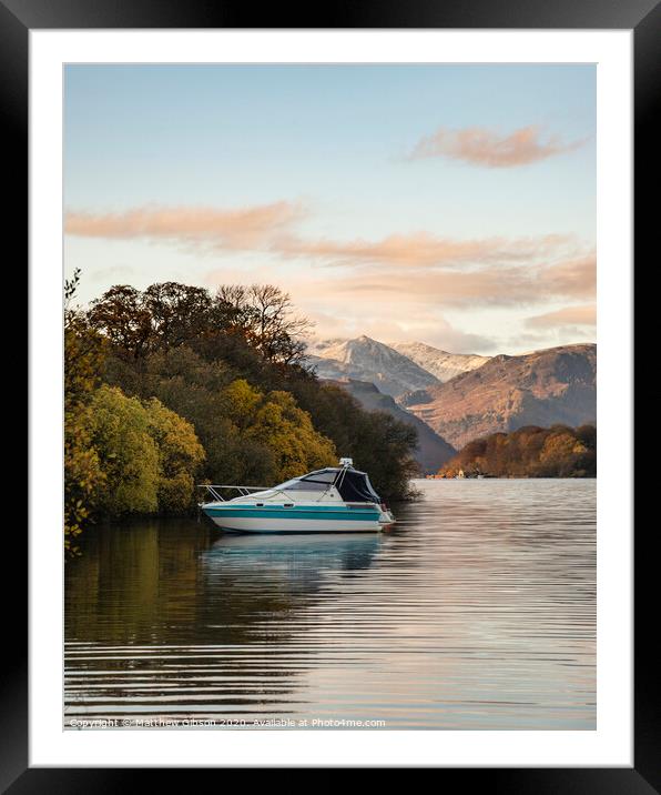 Landscape image of boat moored on Ullswater in Lake District with snowcapped mountains in background with beautiful vibrant Autumn Fall colors Framed Mounted Print by Matthew Gibson