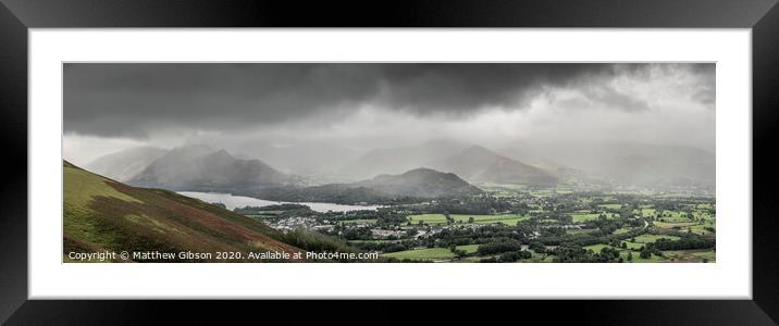 Stunning epic landscape image across Derwentwater valley with falling rain drifting across the mountains causing pokcets of light and dark across the countryside Framed Mounted Print by Matthew Gibson