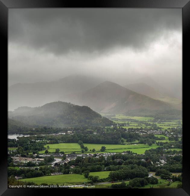 Stunning epic landscape image across Derwentwater valley with falling rain drifting across the mountains causing pokcets of light and dark across the countryside Framed Print by Matthew Gibson