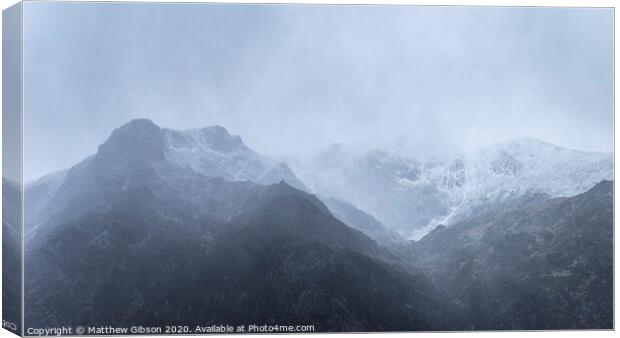 Stunning moody dramatic Winter landscape image of snowcapped Y Garn mountain in Snowdonia Canvas Print by Matthew Gibson